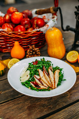 Autumn table setting with pumpkins. Thanksgiving dinner. Salad with chicken breast, cheese and arugula