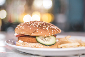 Hamburguesa de pollo con vegetales acompañada de papas a la francesa. 