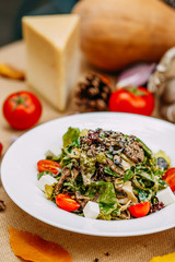 Autumn table setting with pumpkins. Thanksgiving dinner. vegetarian salad with tomatoes and cheese. Healthy food
