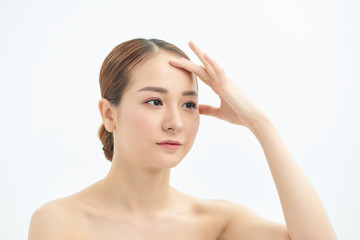 Portrait of beautiful young Asian woman with bare shoulders touching her temples feeling stress, on white background