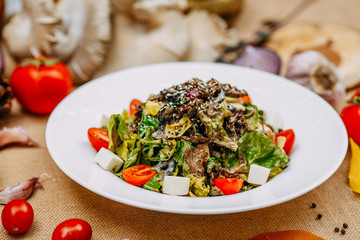 Autumn table setting with pumpkins. Thanksgiving dinner. vegetarian salad with tomatoes and cheese. Healthy food