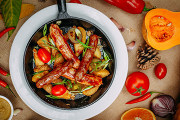 Autumn table setting with pumpkins. Thanksgiving dinner. sausages with fried potatoes in a pan