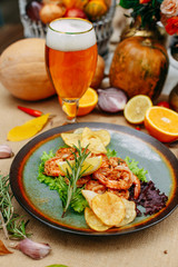 Fototapeta na wymiar Autumn table setting with pumpkins. Thanksgiving dinner. beer shrimp with homemade potato chips