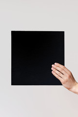 Hands hold a  sheet. Empty space for the label.