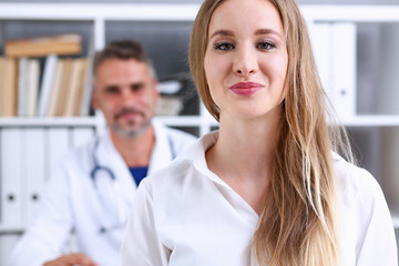 Satisfied happy beautiful smiling female with doctor at his office. High level and quality medical service, therapeutist consultation appointment, work and career, physical, healthy lifestyle concept