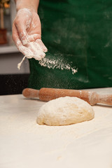 Preparation of the dough for pizza. Hands prepare the dough
