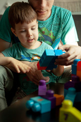 Dad and son playing in the constructor. Self-isolation concept for fighting Covid-19