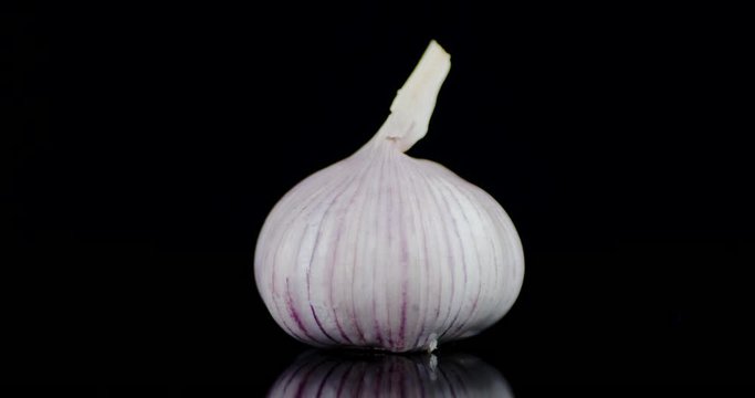 Head of fresh garlic is slowly rotated.