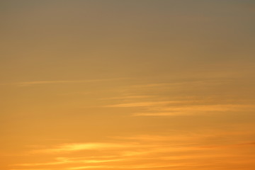 Sun below the horizon and clouds in the fiery dramatic orange sky at sunset or dawn backlit by the sun. Place for text and design.