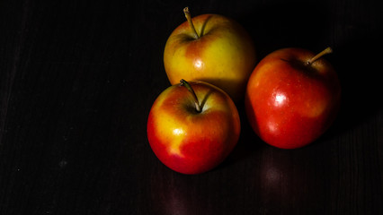Three apples on black background 