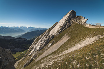 Obraz premium Scenic view of steep rocky mountains and grassy slopes high up in the alps on Mount Pilatus in Lucerne, Switzerland
