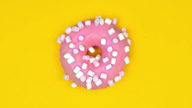 Delicious colorful donuts fast changing on yellow background. Stop motion animation