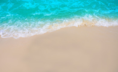 Fototapeta na wymiar Soft Wave Of Blue Ocean On Sandy Beach. Background.