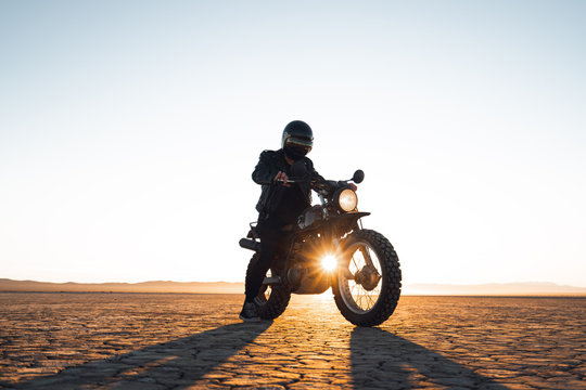 Biker sitting on motorcycle in Death Valley during sunset