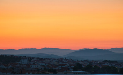 Ancient city by the sea at dawn, sky pink