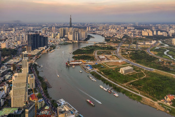 Obraz premium Top view aerial photo from flying drone of a Ho Chi Minh City with development buildings, transportation, energy power infrastructure. Financial and business centers in developed Vietnam.
