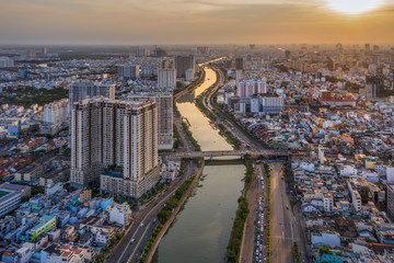Aerial panoramic cityscape view of HoChiMinh city and the Nhieu Loc canar , Vietnam with blue sky at sunset. 