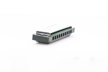 Close-up of a simple metal harmonica in C, isolated on a white background