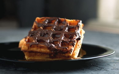 waffles with chocolate on a black plate dessert