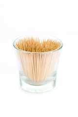 A small glass filled with toothpicks, isolated on white background