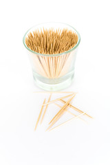 A small glass filled with toothpicks, isolated on white background
