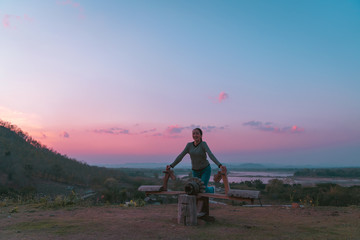 hipster girl posing smile relaxing on Rocking horse toys with holiday relaxing on the mountain in sunset at Northeast at Chiangkhan of Thailand