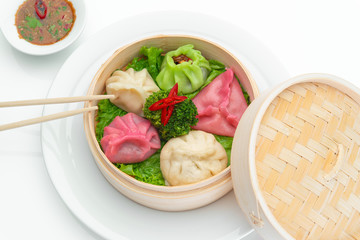 Yummy and hot chinese dumplings on white background. Boiled and hot chinese dumplings close up photo. Hot and tasty chinese dumplings in bamboo steamer