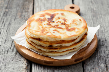 Simply delicious fried flatbreads on wooden table.