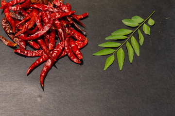 Red Chili, Tomato and Parsley herbs and spices on black wooden background