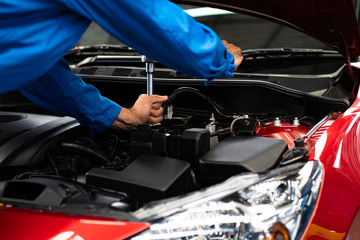 Hands of car mechanic in auto repair service.Car Mechanic Detailed Vehicle Inspection. Auto Service Center Theme. 