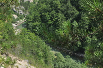 The bridge on the Tara River in Montenegro and the bridge connecting the two banks of the canyon. A stony bed of a clean river flowing through the valley along the road on a mountain slope.