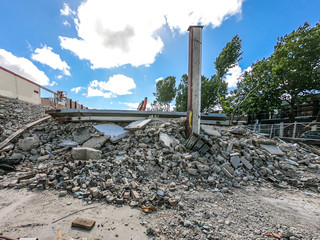 Real building demolition site, destruction, debris, dust, broken bricks, column demolished.