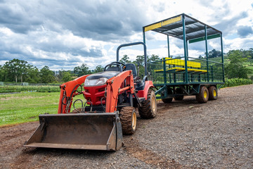 Fototapeta premium Farm bulldoser towing cage cart with yellow benches