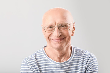 Obraz premium Portrait of elderly man on grey background