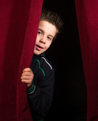 Child appearing beneath the curtain