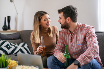 Happy couple preparing to watch football game at home