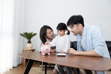 Young Asian mom and dad are saving money with daughter