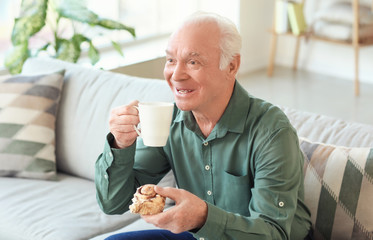 Elderly man drinking tea at home