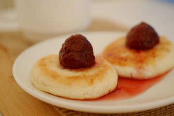 on a white plate with curds on top of the brew of strawberries.