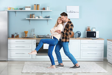 Happy dancing young couple in kitchen