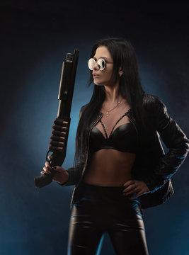 girl in a leather jacket with a shotgun