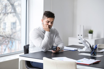 Fototapeta premium Sad man with empty purse in office