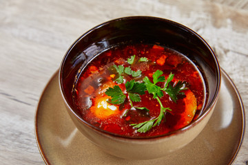 red beetroot soup in bowl garnished with parsley top view