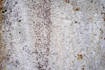 The texture of obsolete concrete with rusty and dark spots.