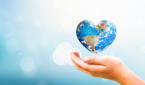 Earth Day concept:  hand hold Earth in Heart shape on Natural background, Elements of this image furnished by NASA