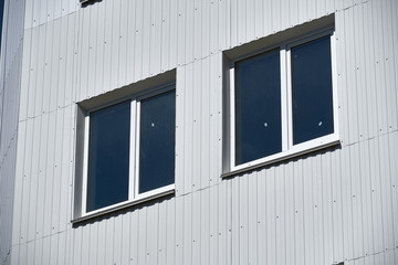 Obraz na płótnie Canvas facade of a new multistory building with white and green metal siding, many Windows