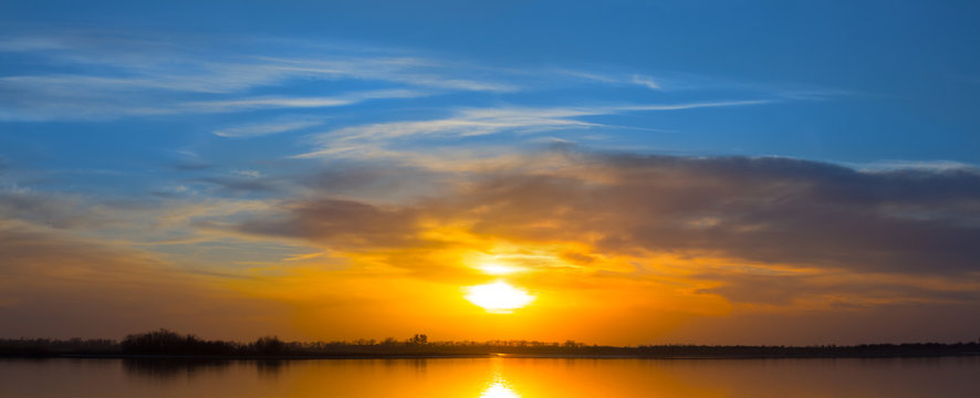 dramatic sunset over the quiet lake, wide evening sky outdoor background