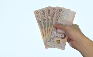 holding banknotes equal five thousand baht Thai
