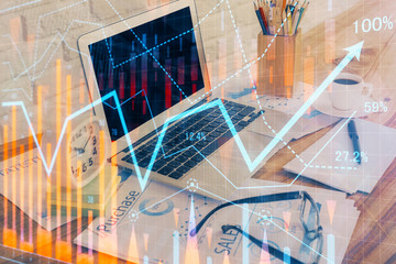 Financial graph colorful drawing and table with computer on background. Multi exposure. Concept of international markets.