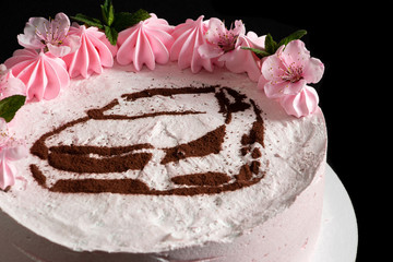 Pink marshmallow cake on a black background with a painted machine